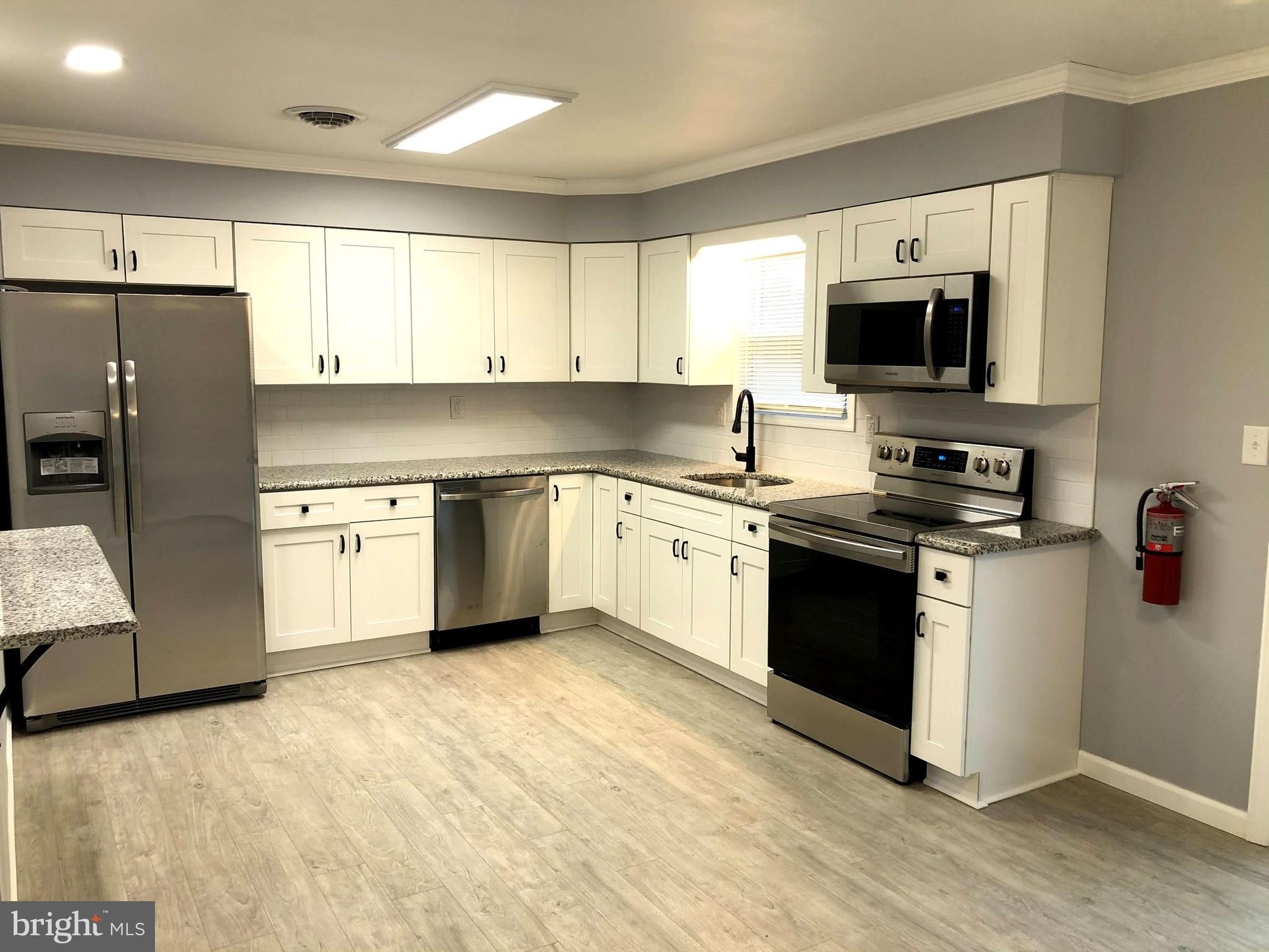 102 Haddon Road Browns Mills, NJ 08015 - Photo 5 of 12 a kitchen with a sink white cabinets and stainless steel appliances
