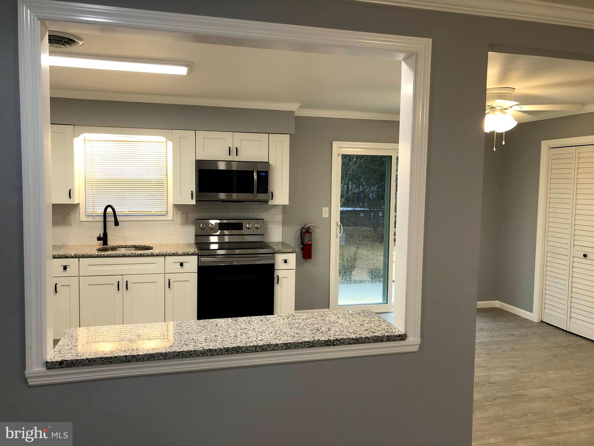 102 Haddon Road Browns Mills, NJ 08015 - Photo 6 of 12 a kitchen with granite countertop white cabinets and black stainless steel appliances