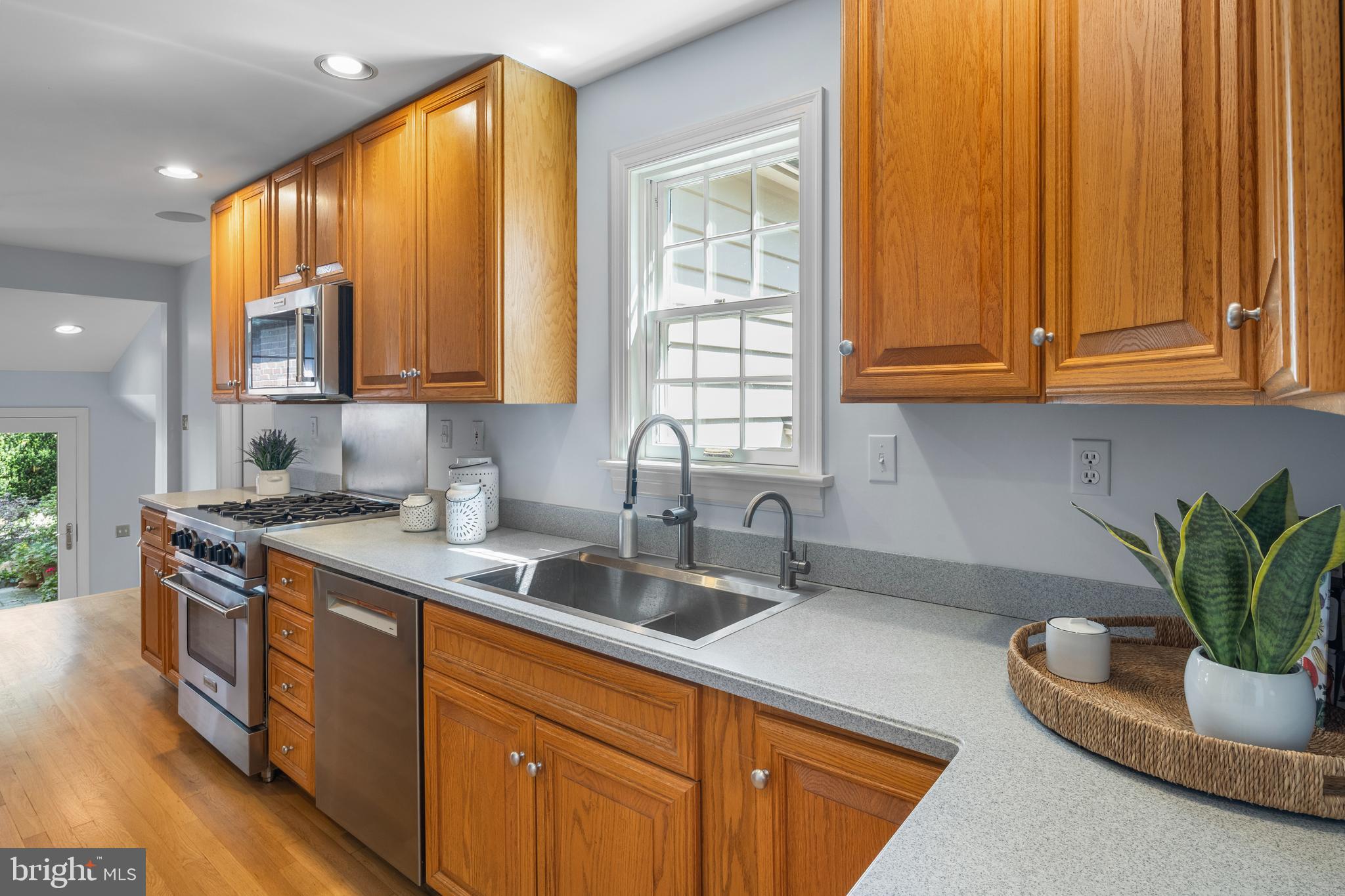 5624 Madison Street Bethesda, MD 20817 - Photo 11 of 28 a kitchen with stainless steel appliances granite countertop a sink a refrigerator and cabinets