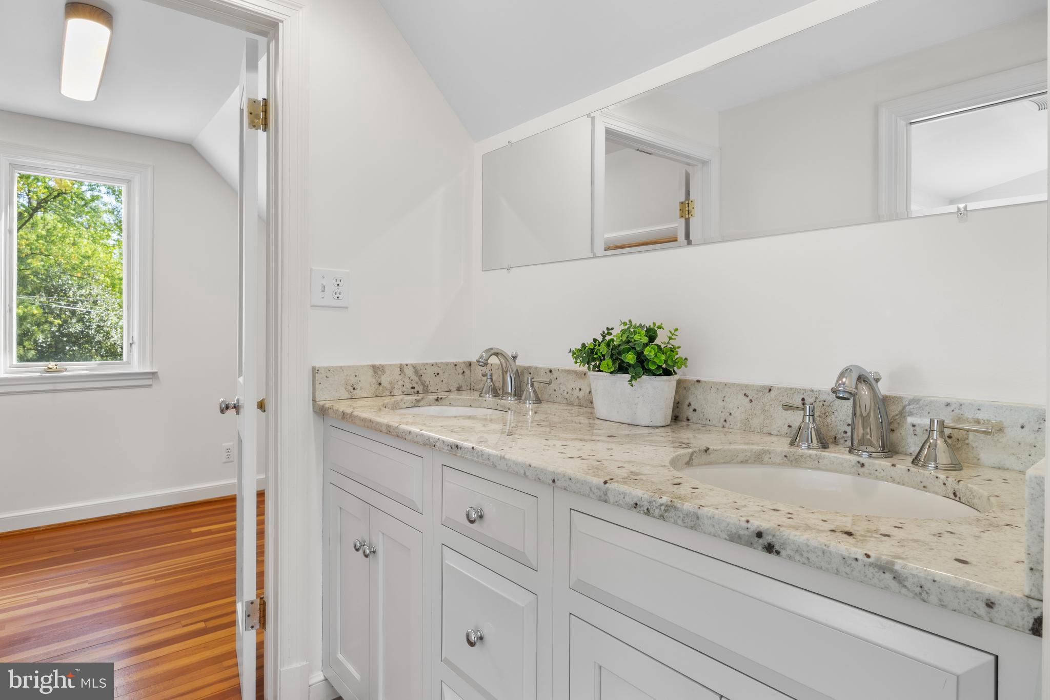 5624 Madison Street Bethesda, MD 20817 - Photo 17 of 28 a bathroom with a granite countertop sink and a mirror