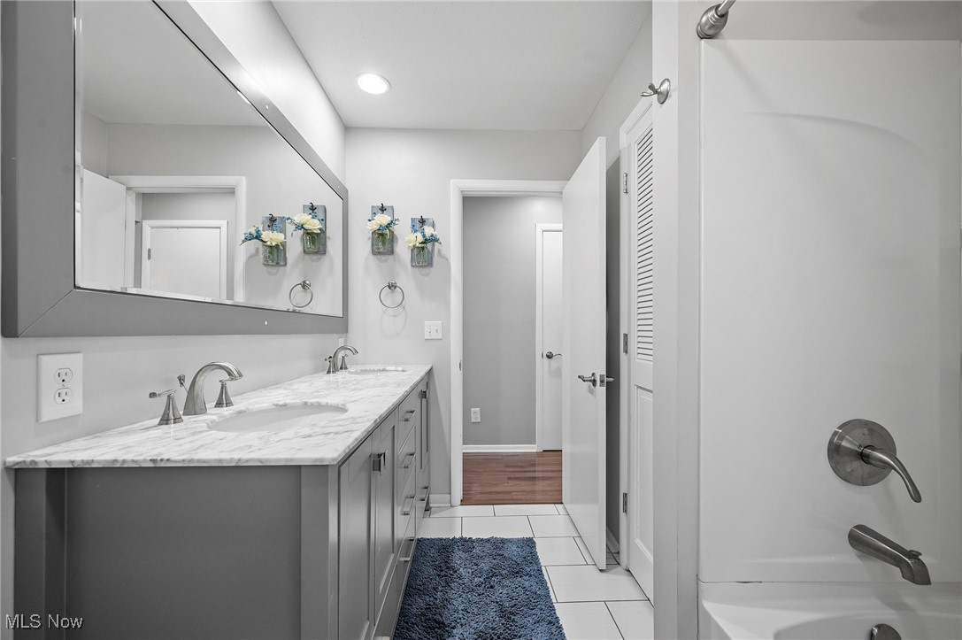 19384 Howe Road Strongsville, OH 44136 - Photo 21 of 40 Bathroom with double vanity, tile patterned flooring, shower / bath combination, and a sink