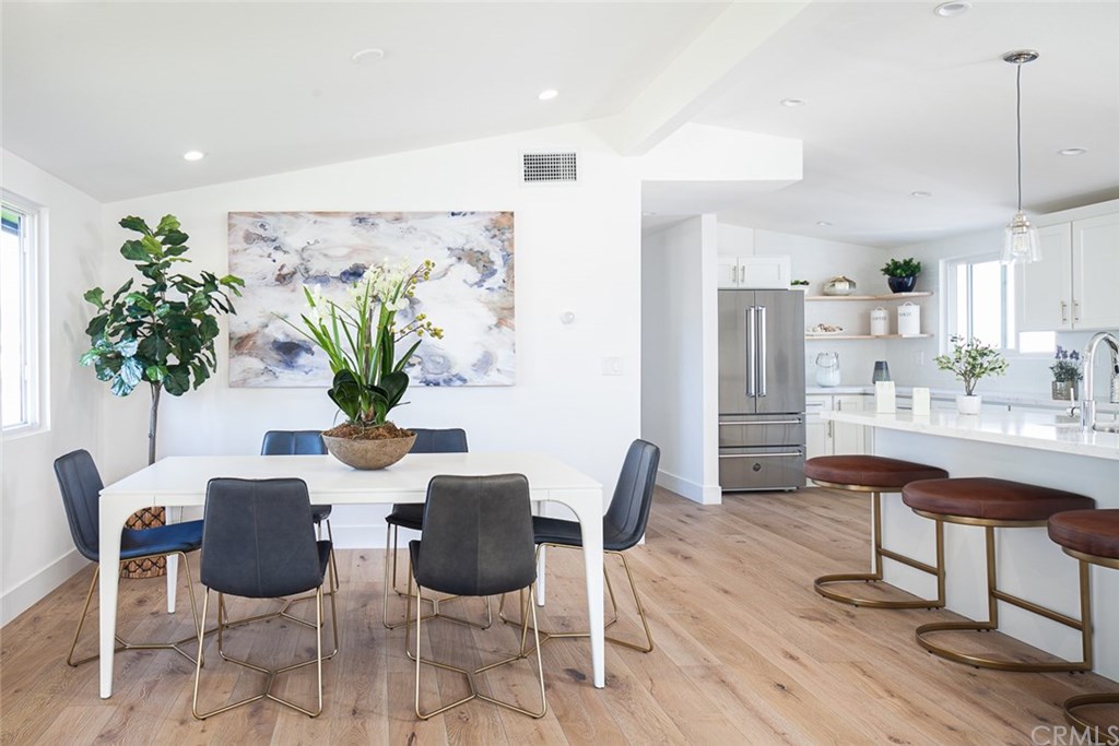 297 Rose Lane Costa Mesa, CA 92627 - Photo 2 of 17 a dining room with furniture potted plants and wooden floor