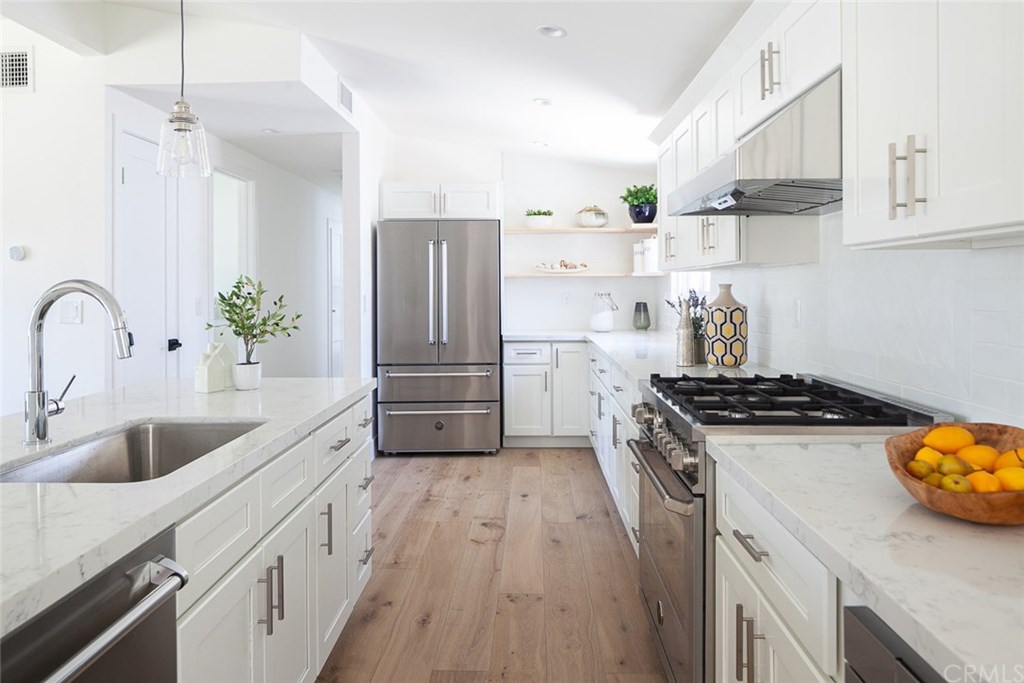 297 Rose Lane Costa Mesa, CA 92627 - Photo 3 of 17 a kitchen with stainless steel appliances granite countertop a sink stove and refrigerator