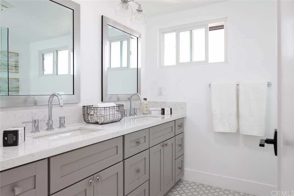 297 Rose Lane Costa Mesa, CA 92627 - Photo 7 of 17 a bathroom with double vanity sink a mirror and a shower