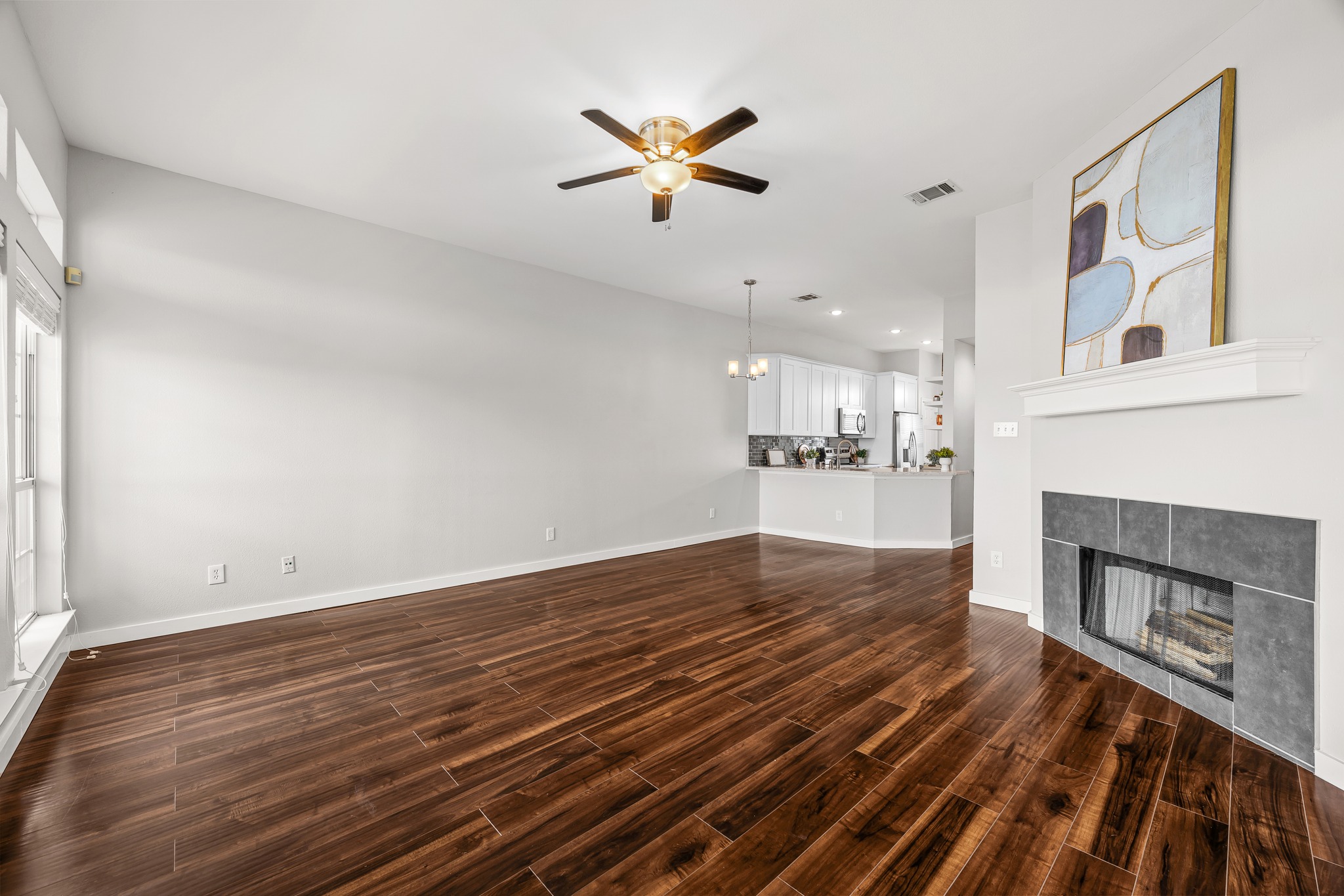 2918 Ranch Road 620 North, Unit S242 Austin, TX 78734 - Photo 14 of 35 Rich hardwood flooring flows through this airy living area, featuring a modern fireplace.