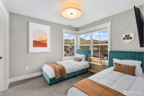 a bedroom with 2 bed and a large window