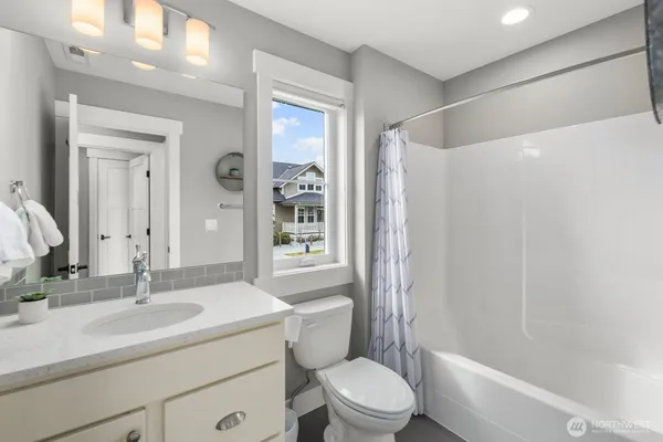 a bathroom with a sink toilet vanity and shower