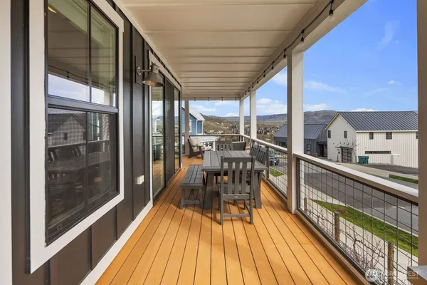 a view of a balcony with chairs and wooden floor