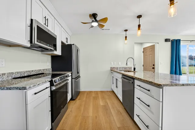a kitchen with stainless steel appliances granite countertop a stove cabinets and microwave