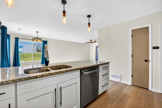 a kitchen with granite countertop a sink and cabinets