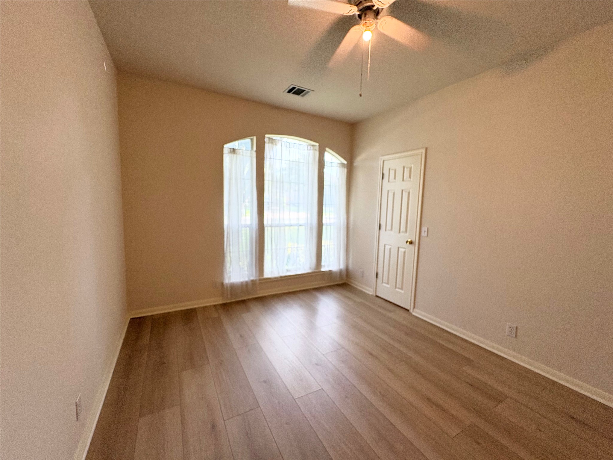 7006 Rambollet Terrace Round Rock, TX 78681 - Photo 27 of 38 Laminate flooring and arched windows enhance this versatile living area.