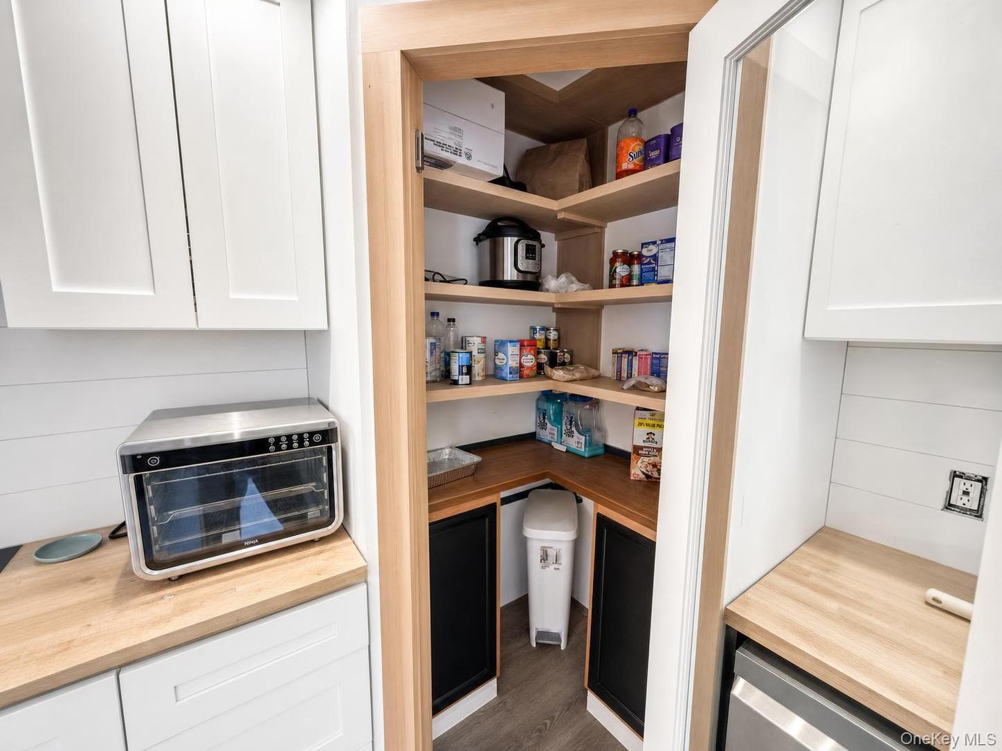 150 Cold Spring Road Liberty, NY 12754 - Photo 8 of 25 Corner pantry featuring wood-finish shelving and countertops, white cabinetry, and shiplap wall accents