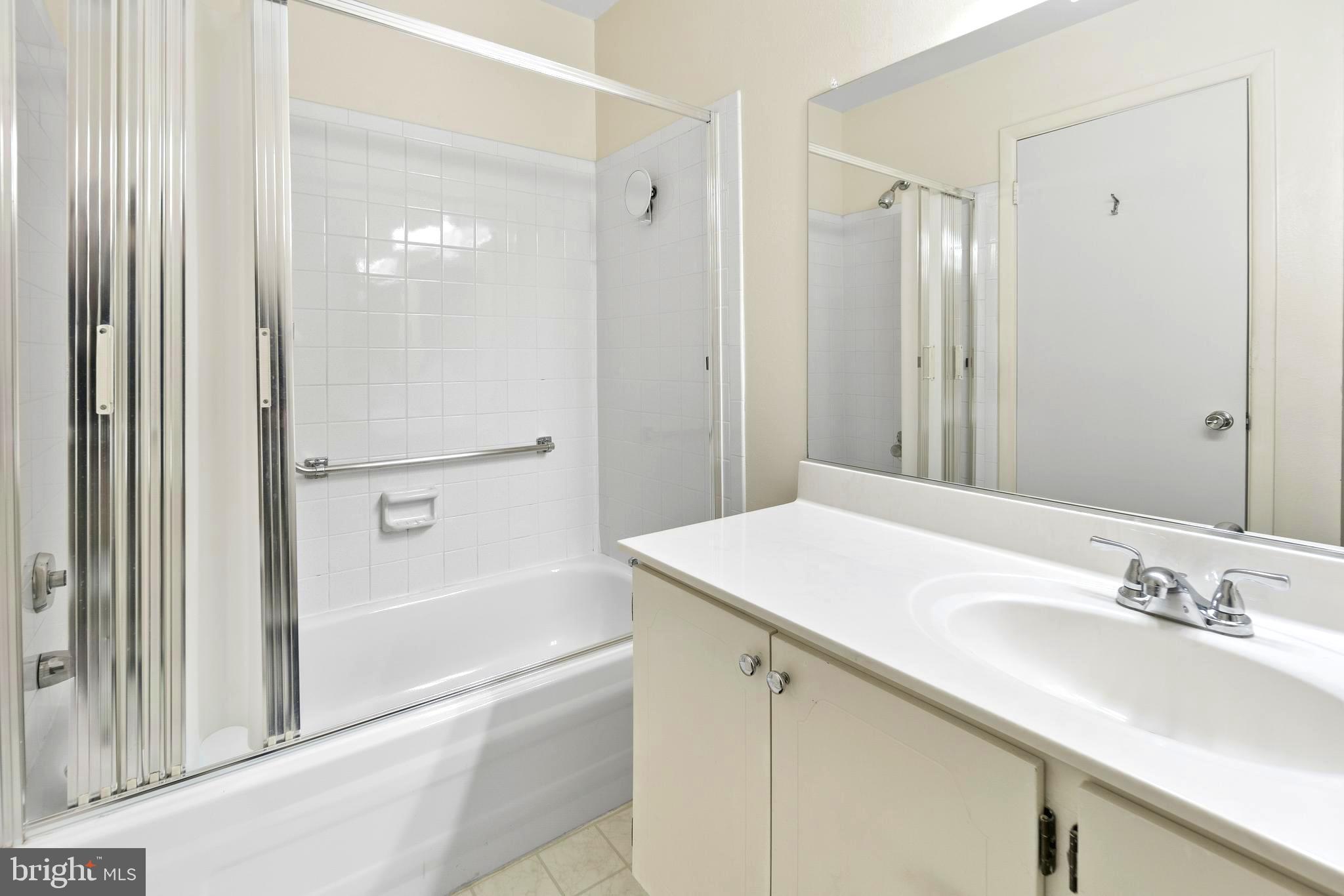 15524 Prince Frederick Way, Unit 118A Silver Spring, MD 20906 - Photo 16 of 31 a bathroom with a granite countertop sink a mirror and a bathtub