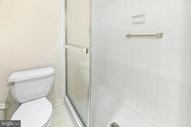 a white toilet sitting next to a shower