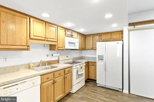 a kitchen with a refrigerator sink and cabinets