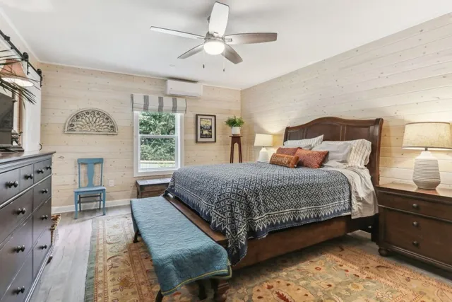 a bedroom with a bed dresser and a window