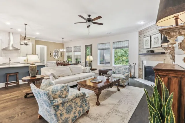 a living room with furniture a fireplace and a chandelier