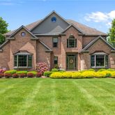 a front view of a house with a big yard and potted plants