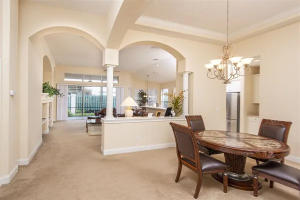 a dining room with furniture a chandelier and wooden floor