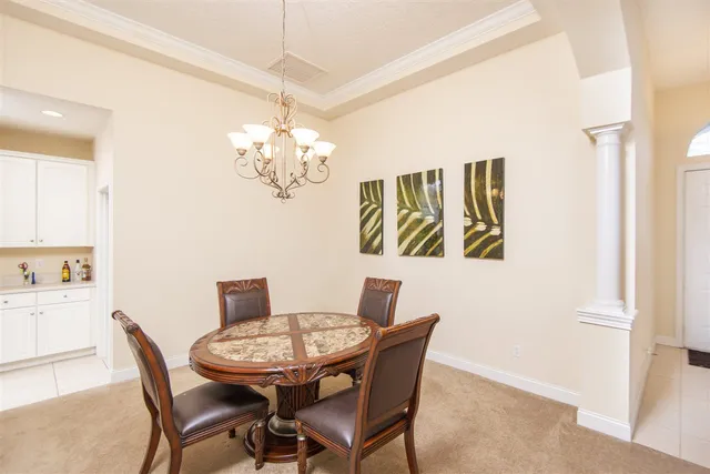 a view of a dining room with furniture and chandelier