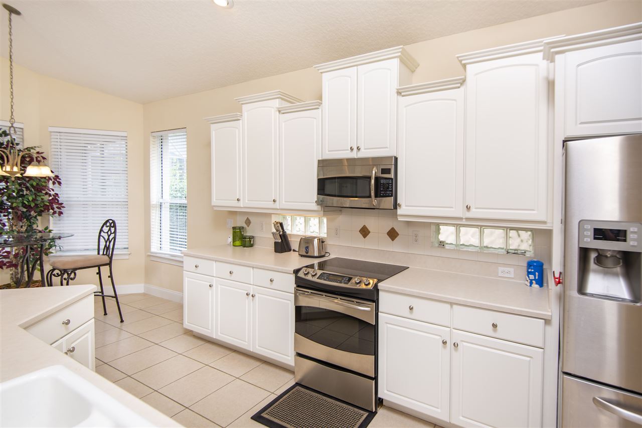128 St Andrews Pl Drive St. Augustine, FL 32092 - Photo 19 of 38 a kitchen with white cabinets and appliances
