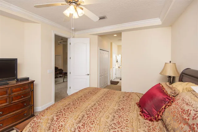 a bedroom with a bed and a flat tv screen on dresser