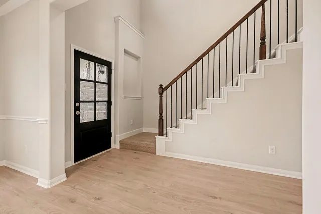 a view of a hallway with wooden floor and entryway