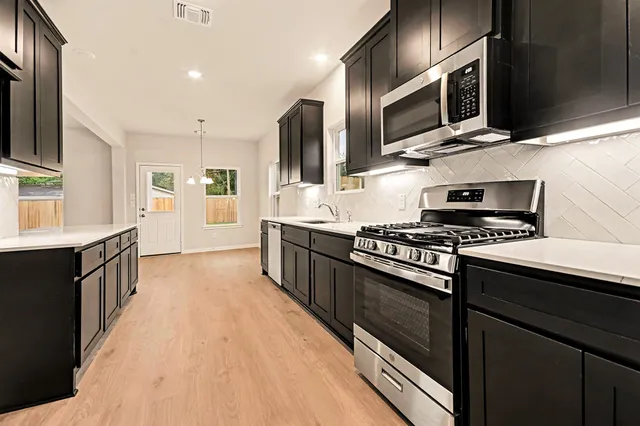 a large kitchen with stainless steel appliances