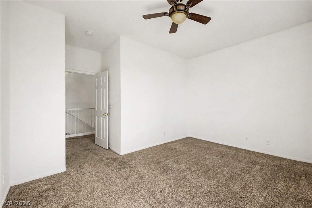 2223 Ramsgate Drive Henderson, NV 89074 - Photo 15 of 32 A well-lit area with textured carpeting features a ceiling fan, offering comfort and convenience.