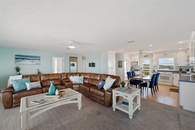 a living room with furniture and a view of kitchen