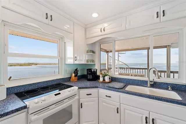 a kitchen with sink a window and cabinets