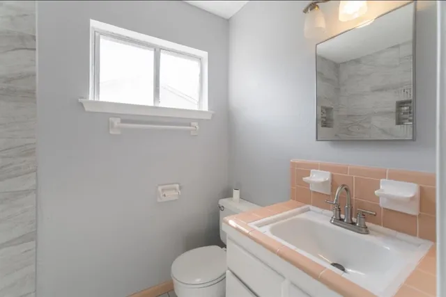 a white toilet sitting next to a bathroom sink