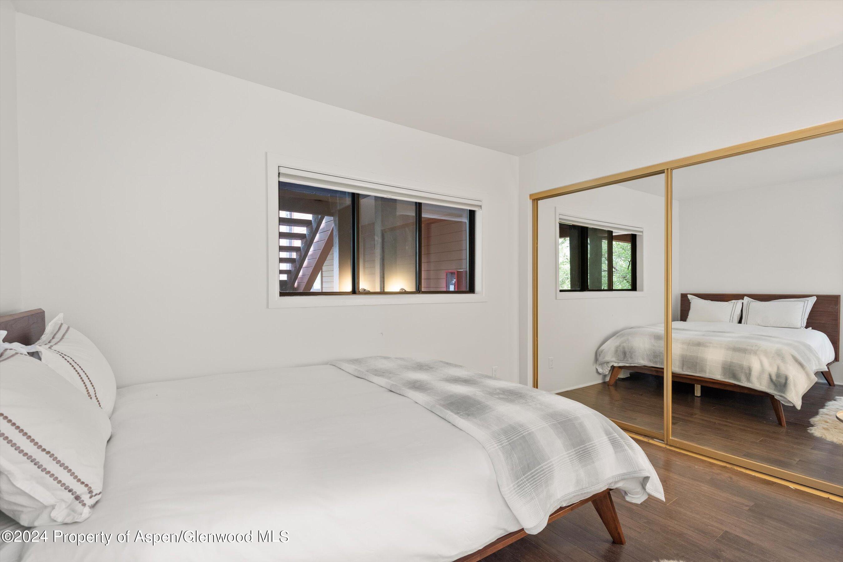 1326 Vine Street, Unit 1326 Aspen, CO 81611 - Photo 11 of 16 a bedroom with a bed wooden floor and window