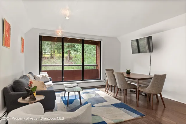 a living room with furniture and floor to ceiling windows