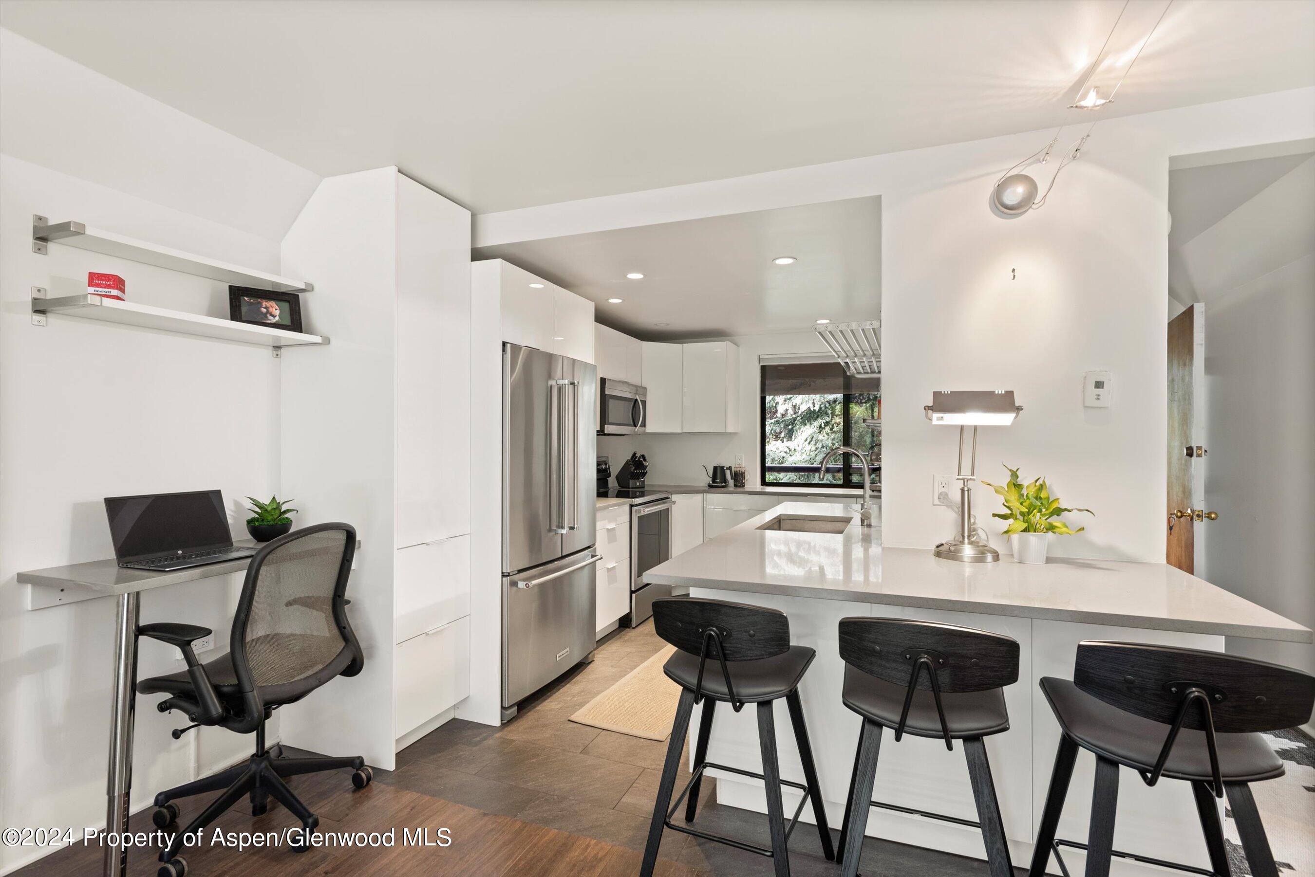 1326 Vine Street, Unit 1326 Aspen, CO 81611 - Photo 5 of 16 a kitchen with stainless steel appliances kitchen island granite countertop a refrigerator and microwave