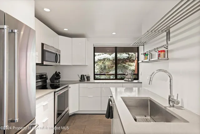 a kitchen with stainless steel appliances a refrigerator a stove a sink and a microwave