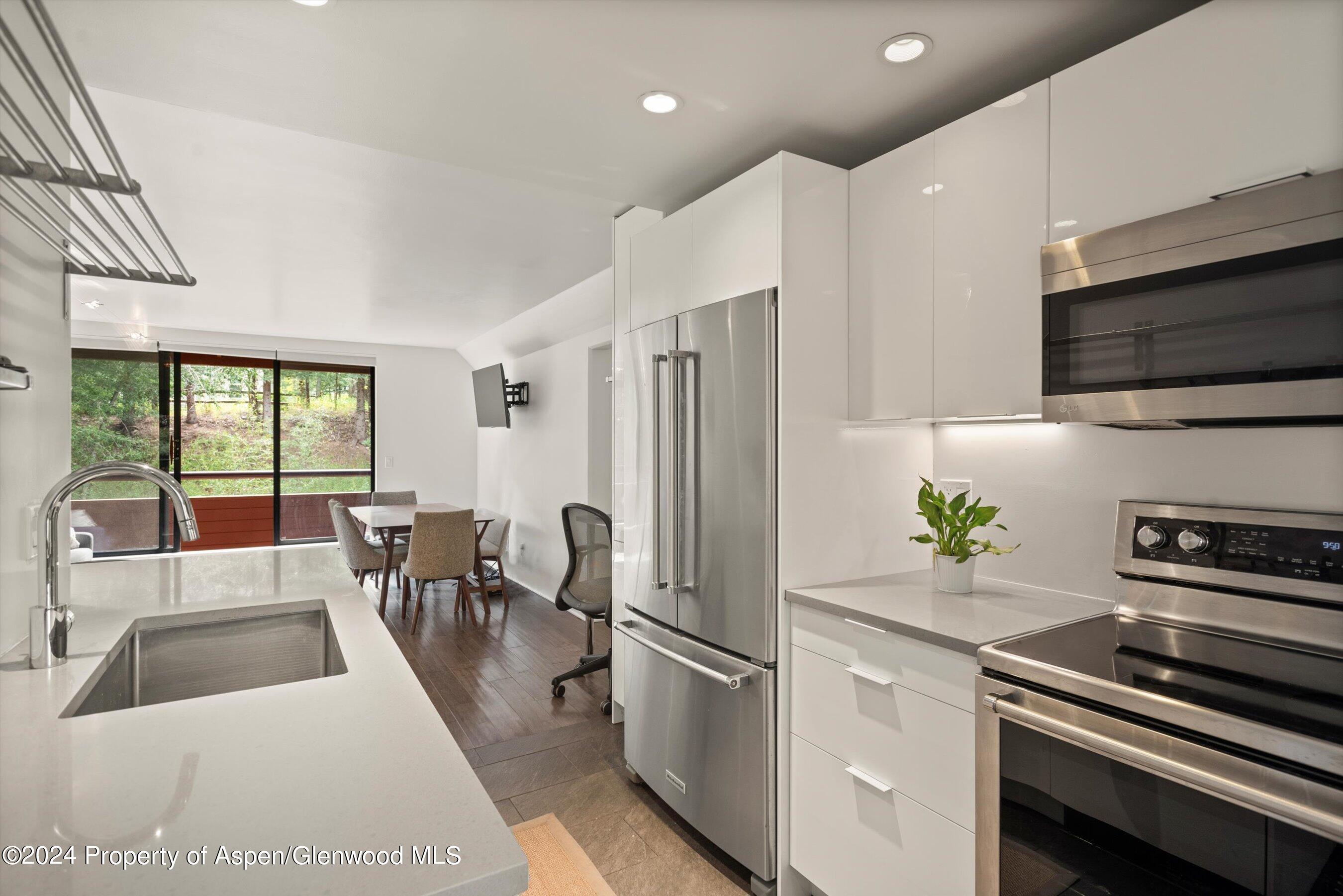 1326 Vine Street, Unit 1326 Aspen, CO 81611 - Photo 7 of 16 a kitchen with stainless steel appliances a refrigerator a stove a sink and a microwave