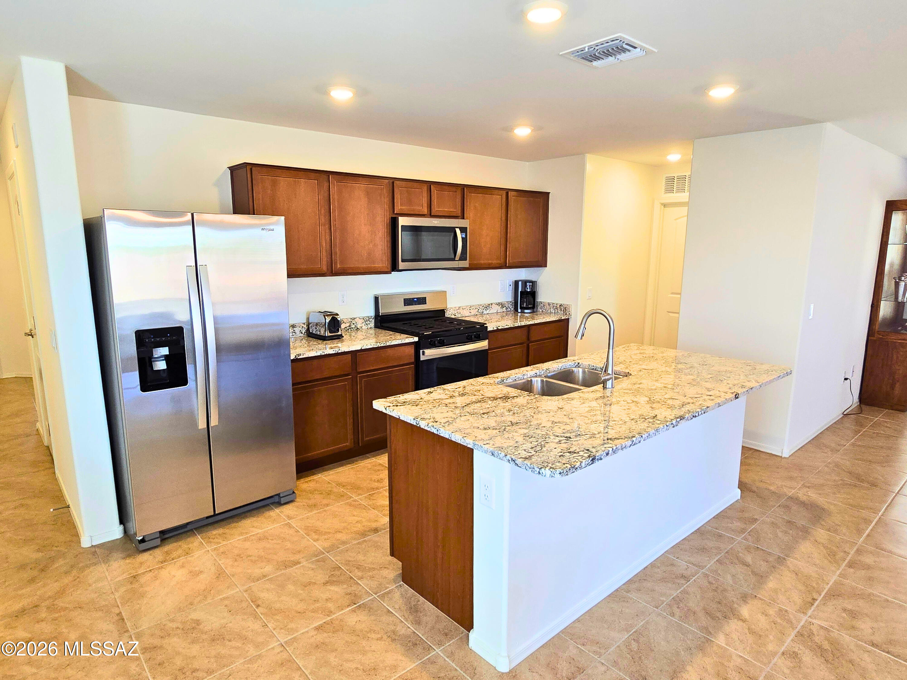 6343 South Rigby Way Tucson, AZ 85746 - Photo 8 of 29 a kitchen with stainless steel appliances granite countertop a refrigerator stove a sink and a microwave