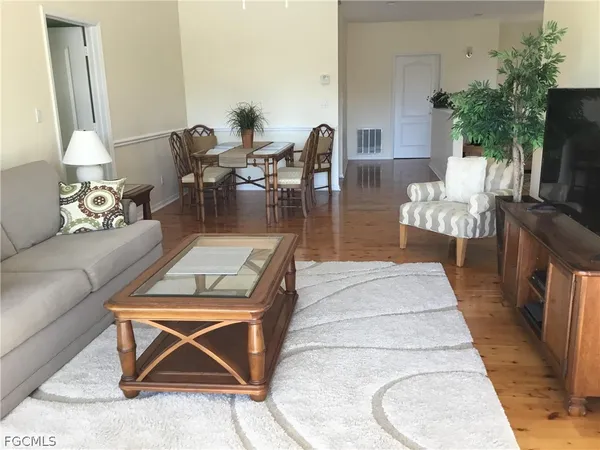 a living room with furniture a dining table and a potted plant