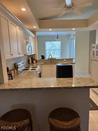 a kitchen with granite countertop a sink a stove and cabinets