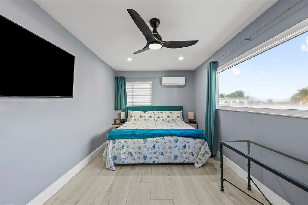 2203 North Surf Road Hollywood, FL 33019 - Photo 39 of 60 a bedroom with a bed a flat screen tv and a large window