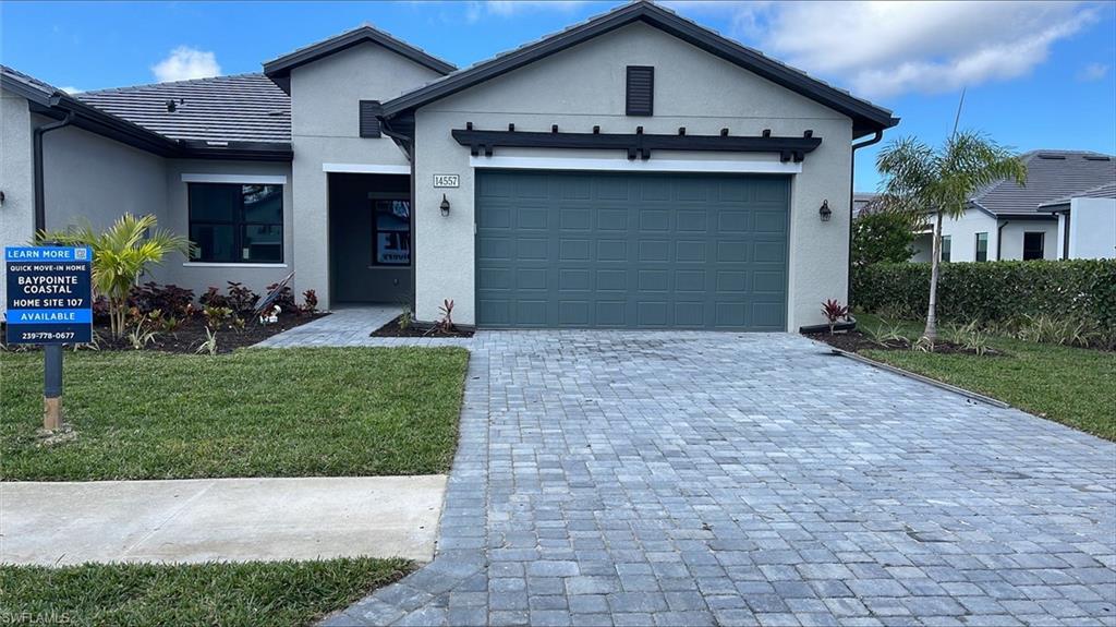 14557 Kingfisher Loop Naples, FL 34120 - Photo 2 of 27 a front view of a house with a yard and garage