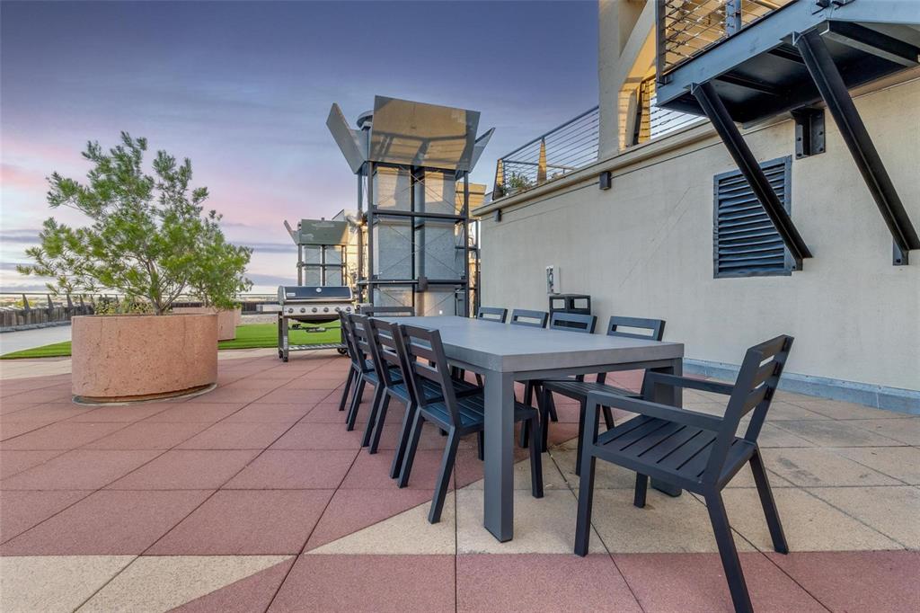 2220 Canton Street, Unit 101 Dallas, TX 75201 - Photo 15 of 20 Rooftop patio featuring expansive tiled flooring with geometric patterns, a large rectangular dining table, and a built-in planter with established greenery