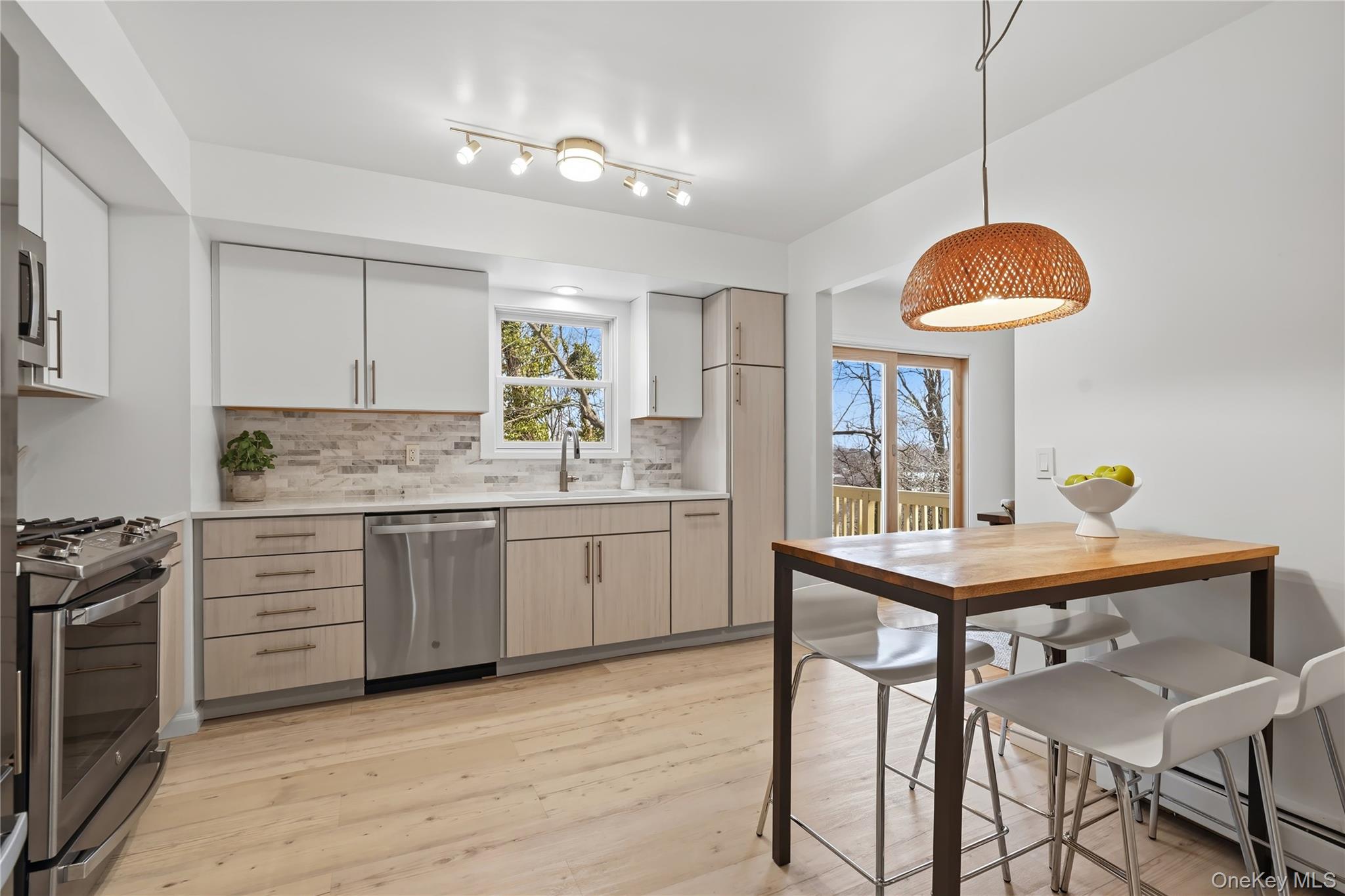 166 Highview Street Mamaroneck, NY 10543 - Photo 3 of 30 a kitchen with a table a sink cabinets and appliances