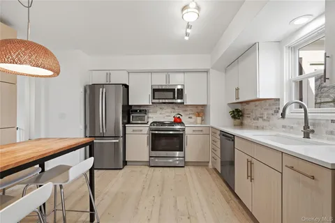 a kitchen with stainless steel appliances a stove refrigerator sink and microwave
