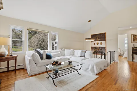 a living room with furniture large window and wooden floor