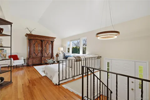 a view of a livingroom with furniture wooden floor windows and a chandelier