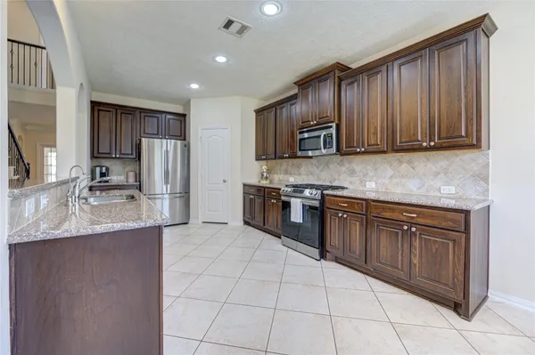 a spacious bathroom with a granite countertop sink a mirror a bathtub and shower