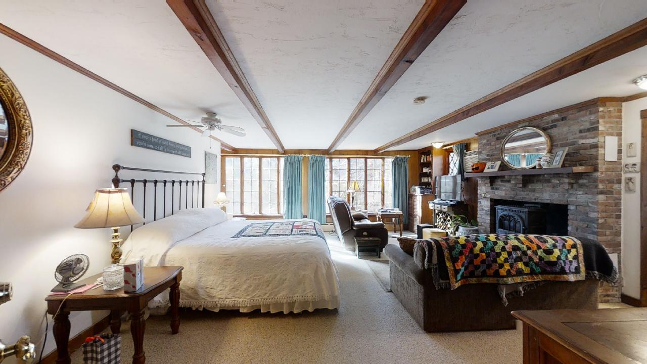152 Whig Street Dennis, MA 02638 - Photo 12 of 35 a bedroom with furniture and a fireplace
