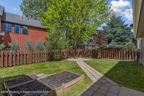 a view of backyard with wooden fence